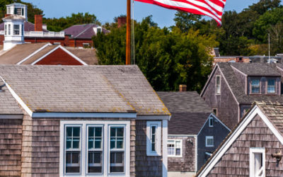 nantucket-usa American flag waving above historic Nantucket shingle cottages on a clear day