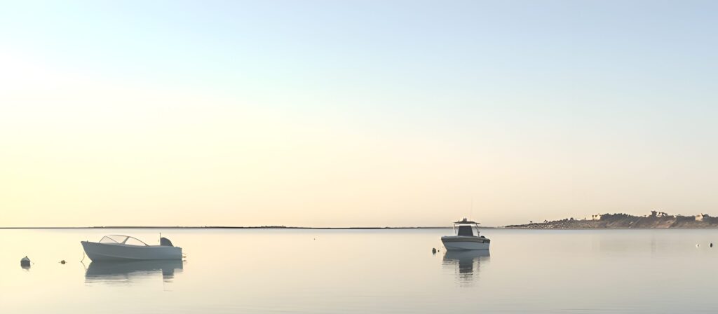 Small boats moored on calm water at Polpis Harbor, Nantucket, at dawn
